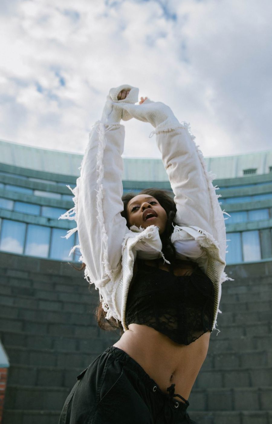 A woman dancing in front of a big building
