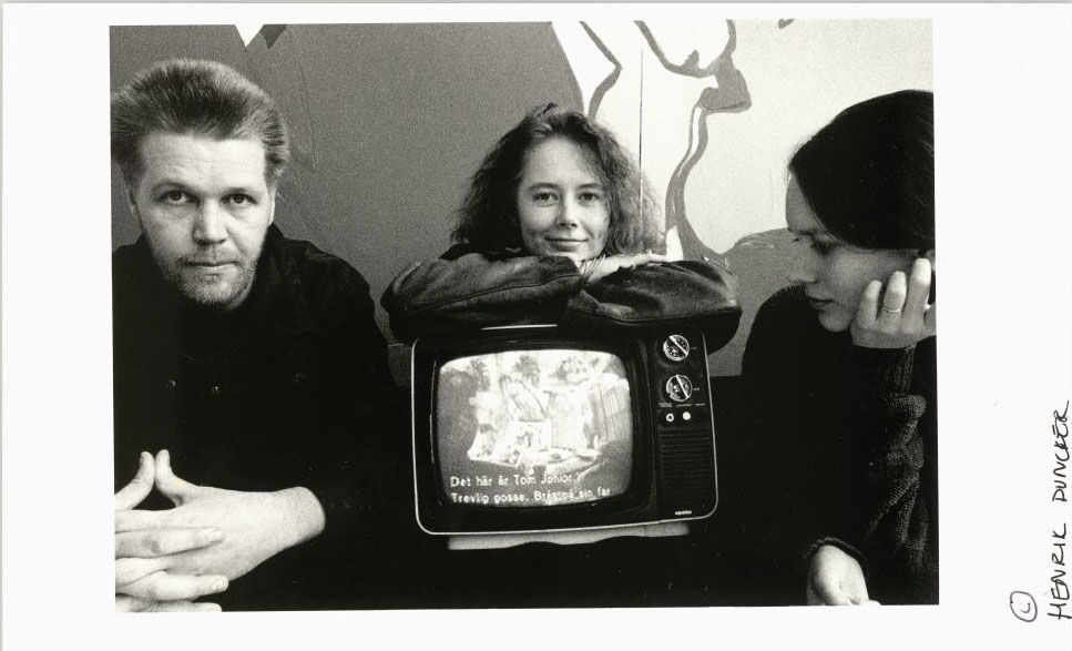 a man and two women posing with tv