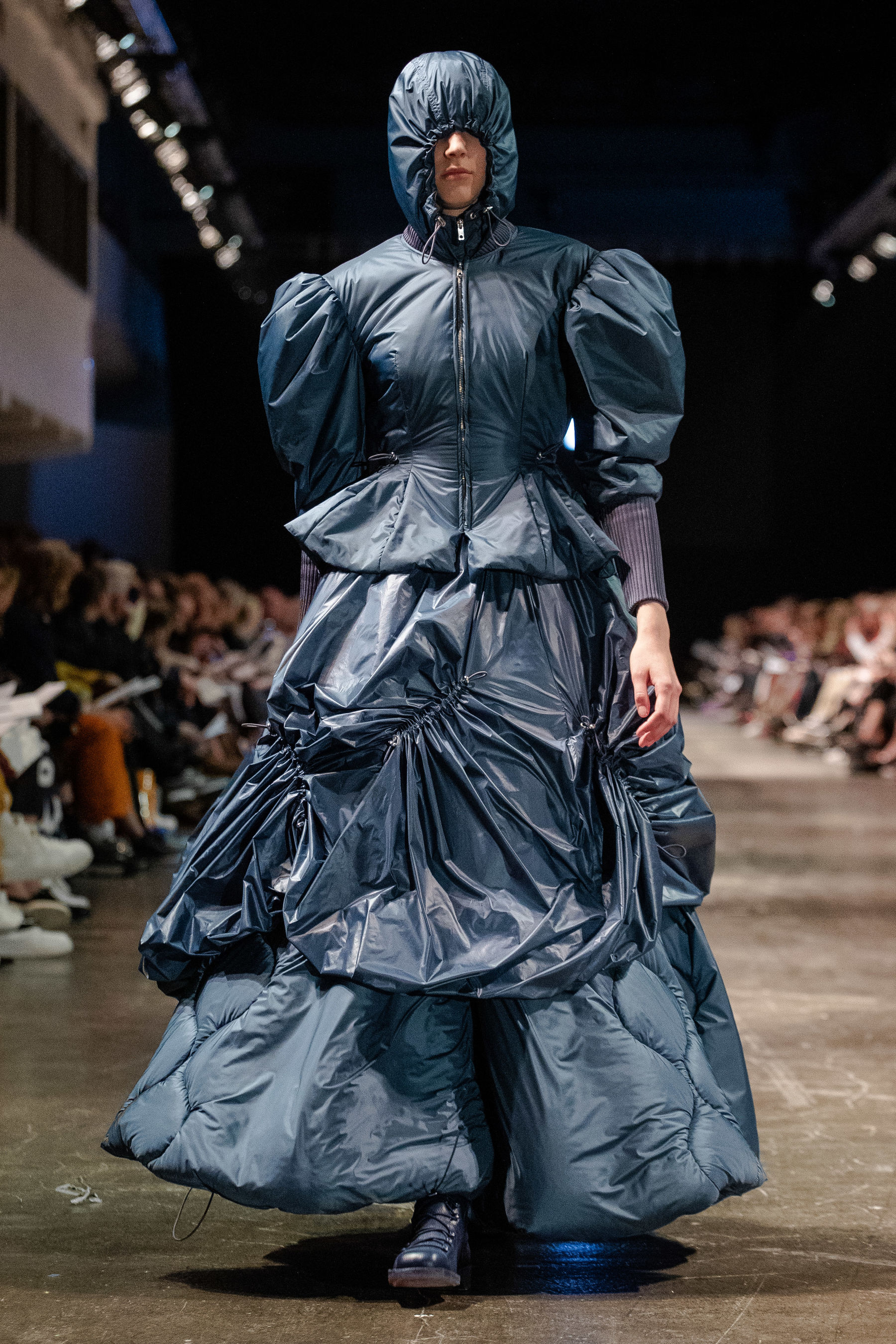 Model walking down catwalk in blue fluffy dress
