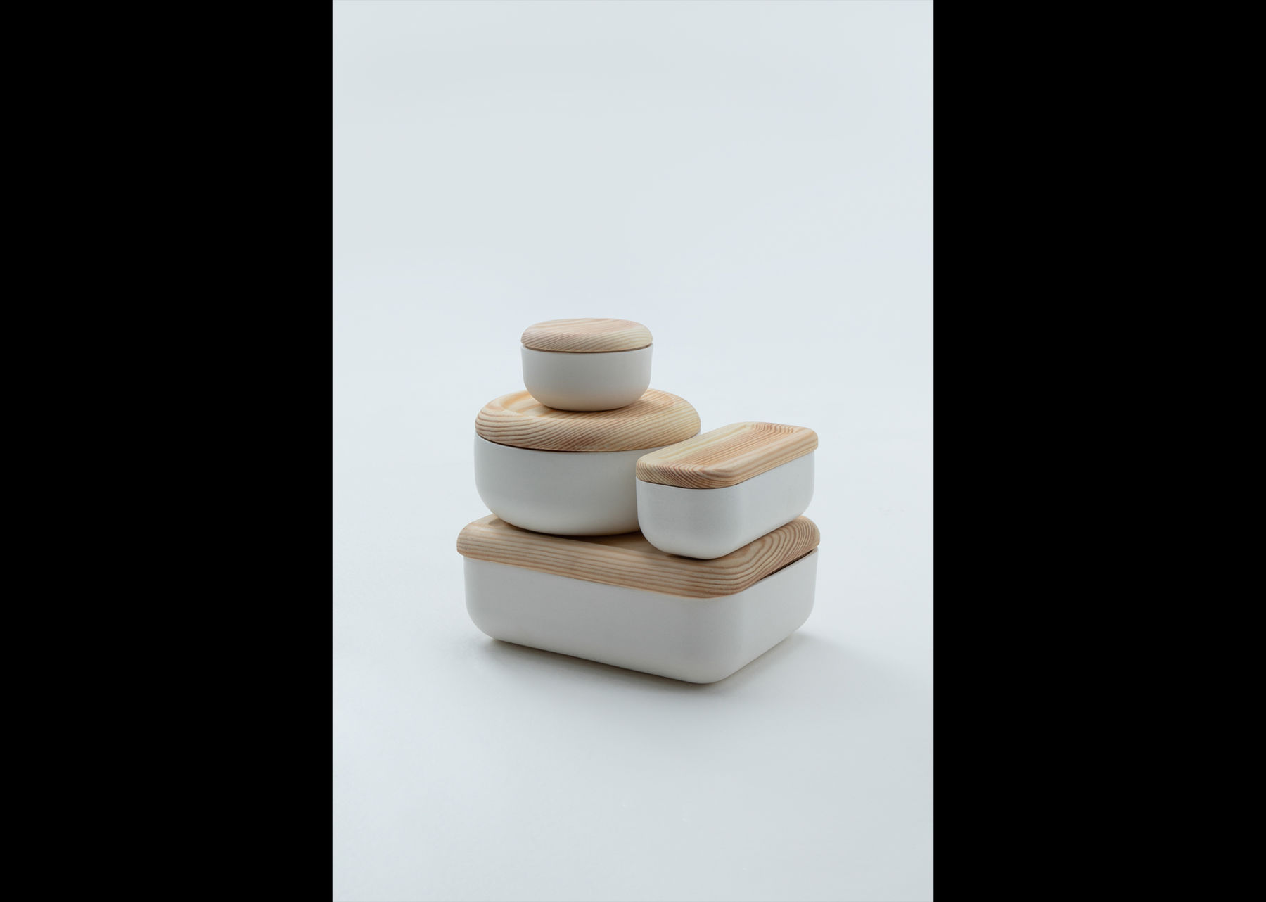 a set of white/wood -coloured bento boxes made of ceramics, pine, ash and silicone