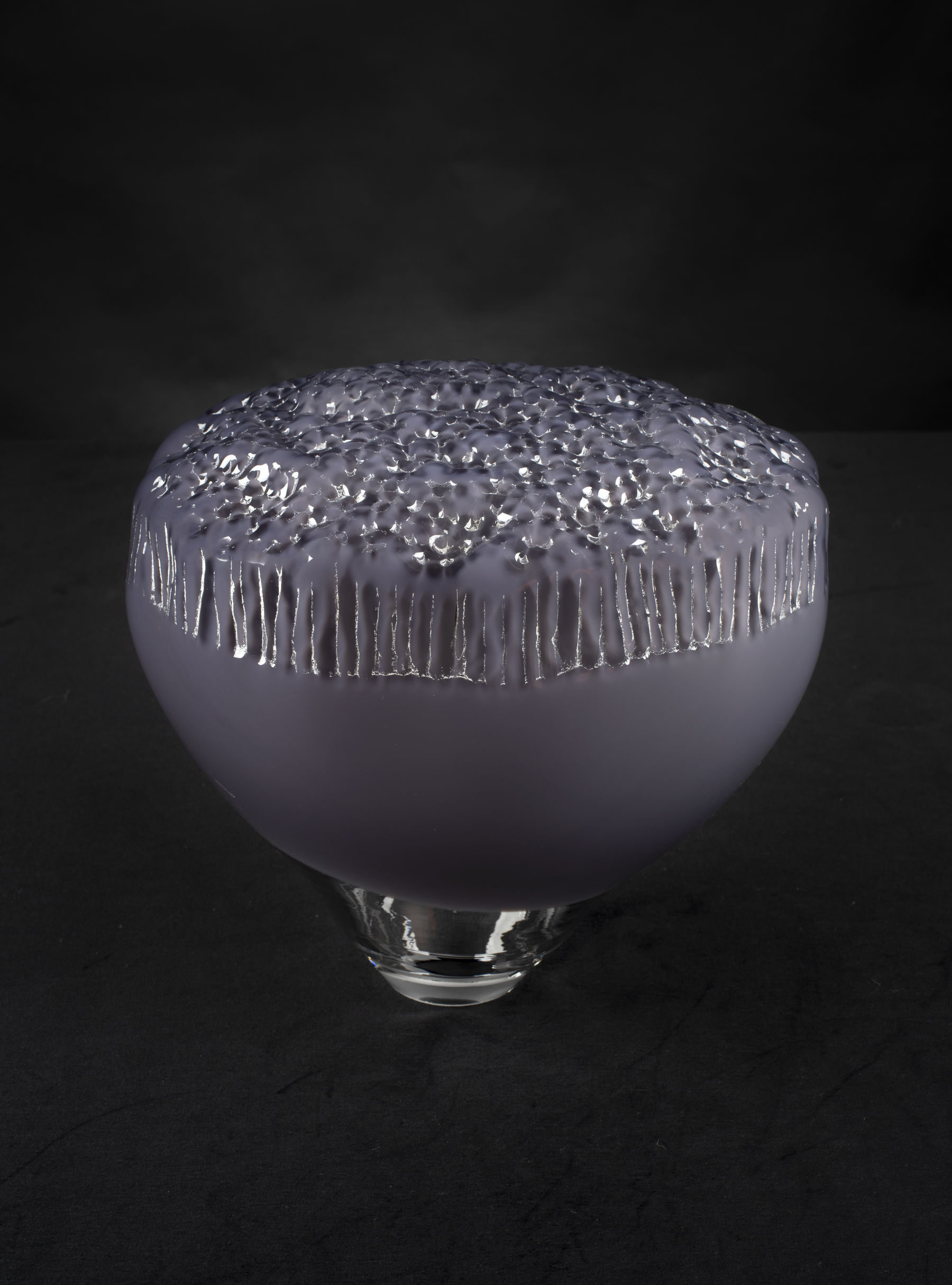 a purple glass sculpture with silvery details