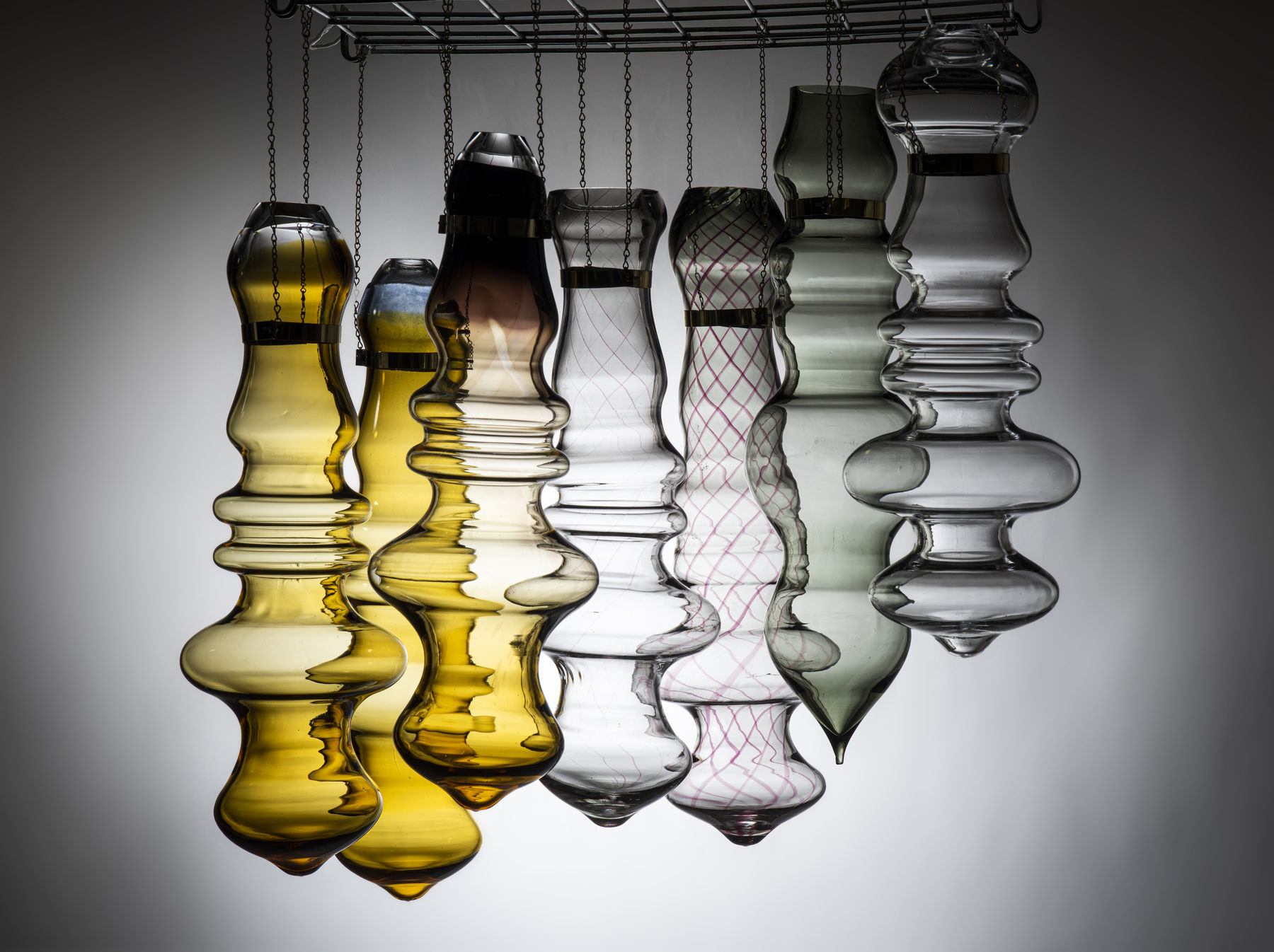 seven bubbly shaped glass objects hanging