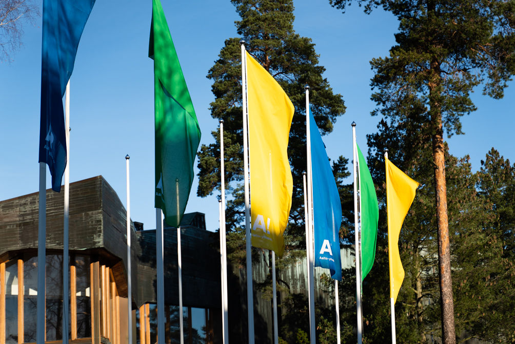 Yellow, Green and Blue Aalto University flags waving