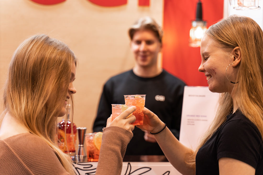 Students enjoying a complementary drink on a stand