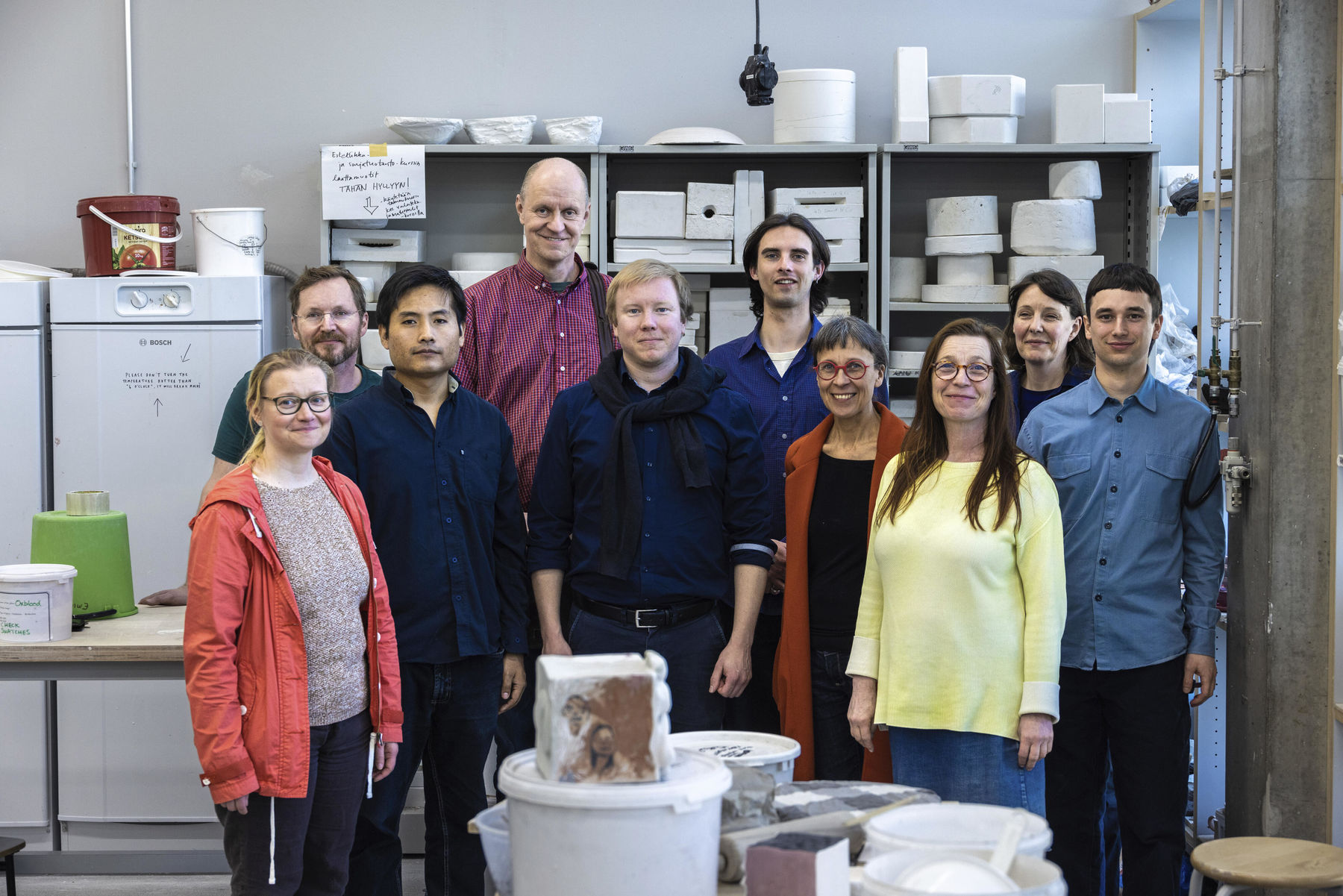 A group of people posing in a ceramic studio