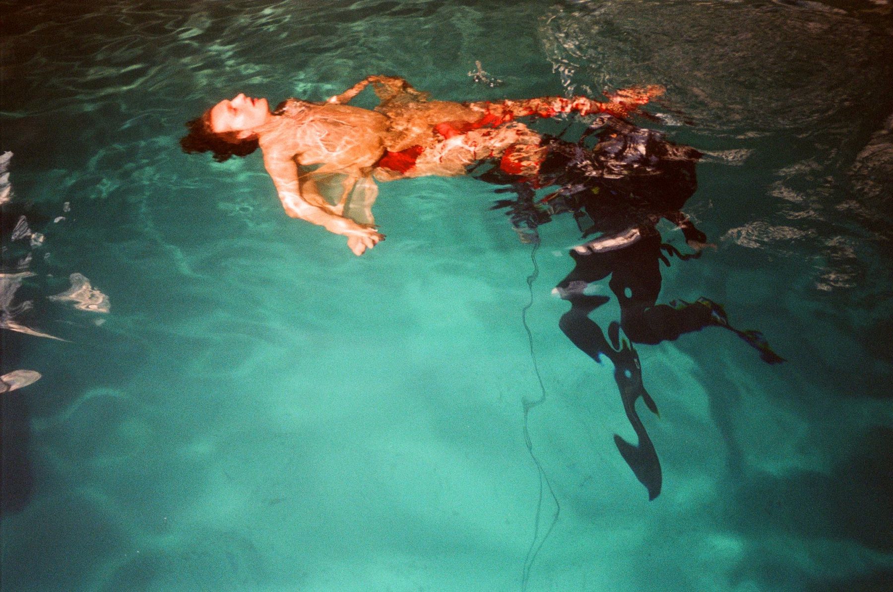 A man floating in a swimming pool