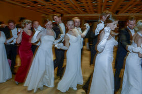 Kuvassa tanssivia juhlapukuun pukeutuneita vieraita