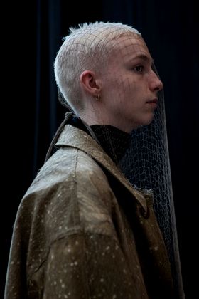 Model with blonde hair with a fish net over his head