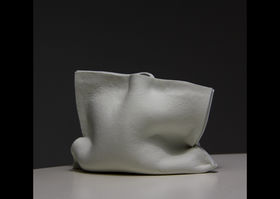 a white ceramic bag-like vase