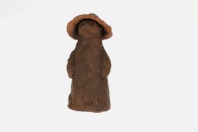 A hand made clay sculpture without glazing. It looks like a forrest wizzard or creature with a sunhat