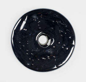 almost black-coloured round glass piece with a hole in the middle