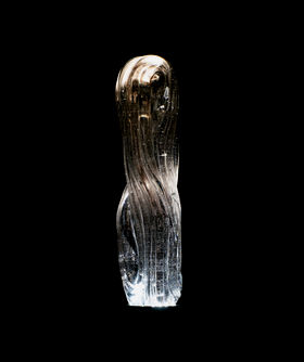 an organic shaped glass sculpture with black background