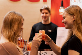 Students enjoying a complementary drink on a stand