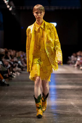 model on runway in yellow suit with shorts