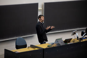 Professor standing in front of two blackboards