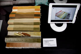 Pieces of coloured textiles on display on a table along with a screen to find out more on the research project 
