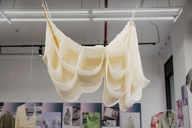 A soft natural white cloth structure hanging from the ceiling in a gallery exhibition in New York