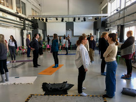People standing in pairs facing each other doing a practice during the CBCR workshop.