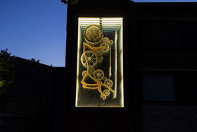 Pekka and Teija Isorättyä's artwork Lovegear on the façade of K2 building at night. The artwork is a cinetic sculpture that creates the illusion of continuing inside through the wall.