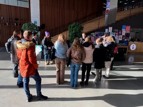 A group of people listening a guide during a campus tour 