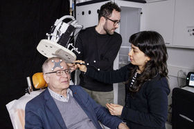 Three researchers demonstrating the use of brain imagining device