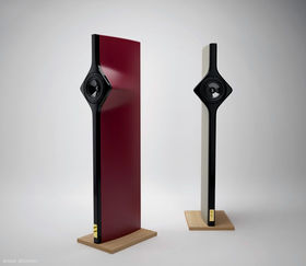 Futiristic looking flat speaker standing on a wooden podium. Red and white versions in the picture.