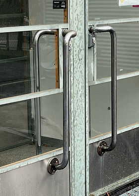 Glass door with large and long vertical metal handles