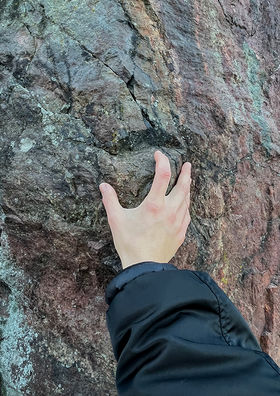A hand touching a rock