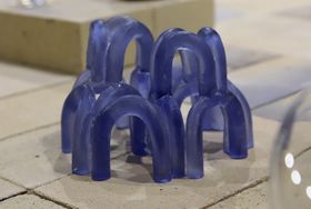 A blue glass sculpture made of arc like shapes