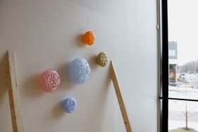 A collection of colourful, round glass objects mounted on a wall