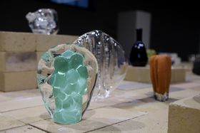 A collection of glass objects, a clear glass sculpture with a pastel green core at the front