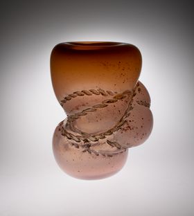 Traces of rope on a bulbous orange glass sculpture 