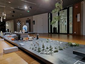 Exhibition set up: Glass objects presented alongside pine tree branches