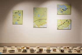 4 maps on the wall and underneath ceramic mugs with traces of different soil