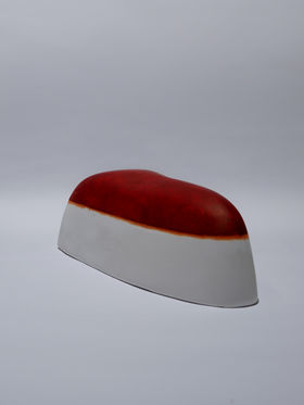 A curved white shape painted with a red substance