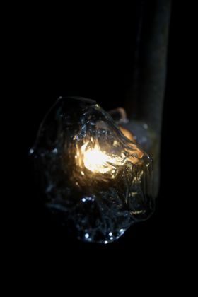 Light shining through an organically sahped clear glass lampshade