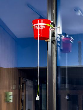 A red bucket fastened to the window