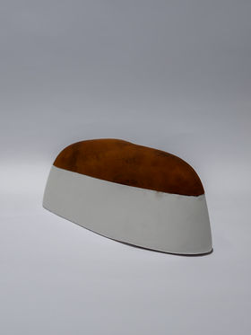 A curved white shape painted with a brown substance
