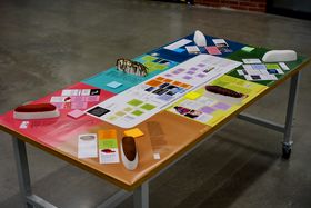 A table with a colourful presentational poster with hull coating samples on it