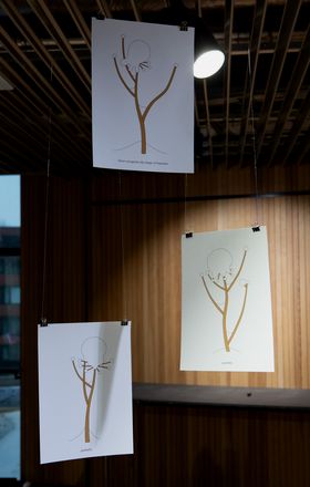 three drawings suspended from the ceiling