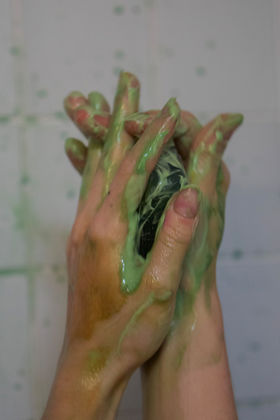 Hands using the green foamy algae soap