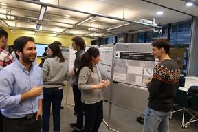 Students watching posters about machine learning.