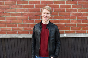 Aleksanteri smiling in front of the School of Chemical Engineering
