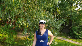 Jonna in a ballgown in the park wearing a Teekkari cap