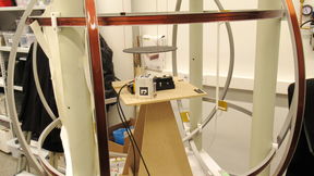 Magnetic testbed, with visual markers attached on the device-under-test and sensing magnetometer, set up inside a cage of Helmholtz coils