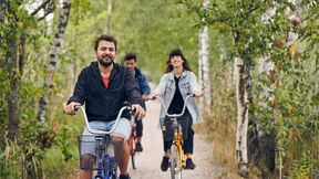 Three students cycling in Otaniemi in the summer