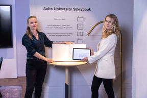 Julia Sand and Jennifer Greb displaying Aalto University storybook at the Welcome lounge in Dipoli. Photo: Mikko Raskinen 