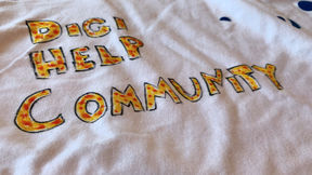 A white t-shirt with Digi help community written with yellow and red markers.