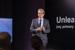 Professor Matti Sarvimäki gives a presentation on a stage.
