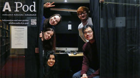 Five students posing in a mini podcast studio at Aalto University